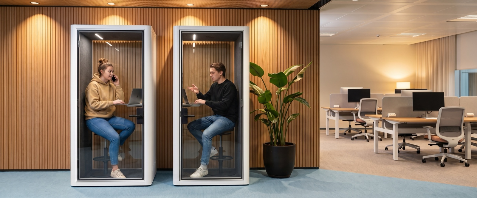 Two people taking solo calls in Sona booths